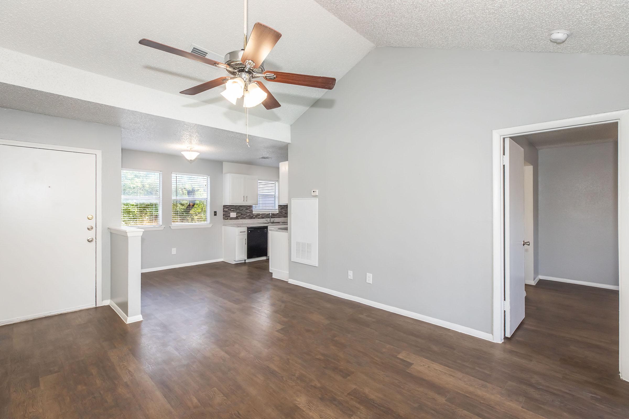 Sala y comedor abiertos hacia la cocina en un apartamento de 1 recámara en Providence at Domain