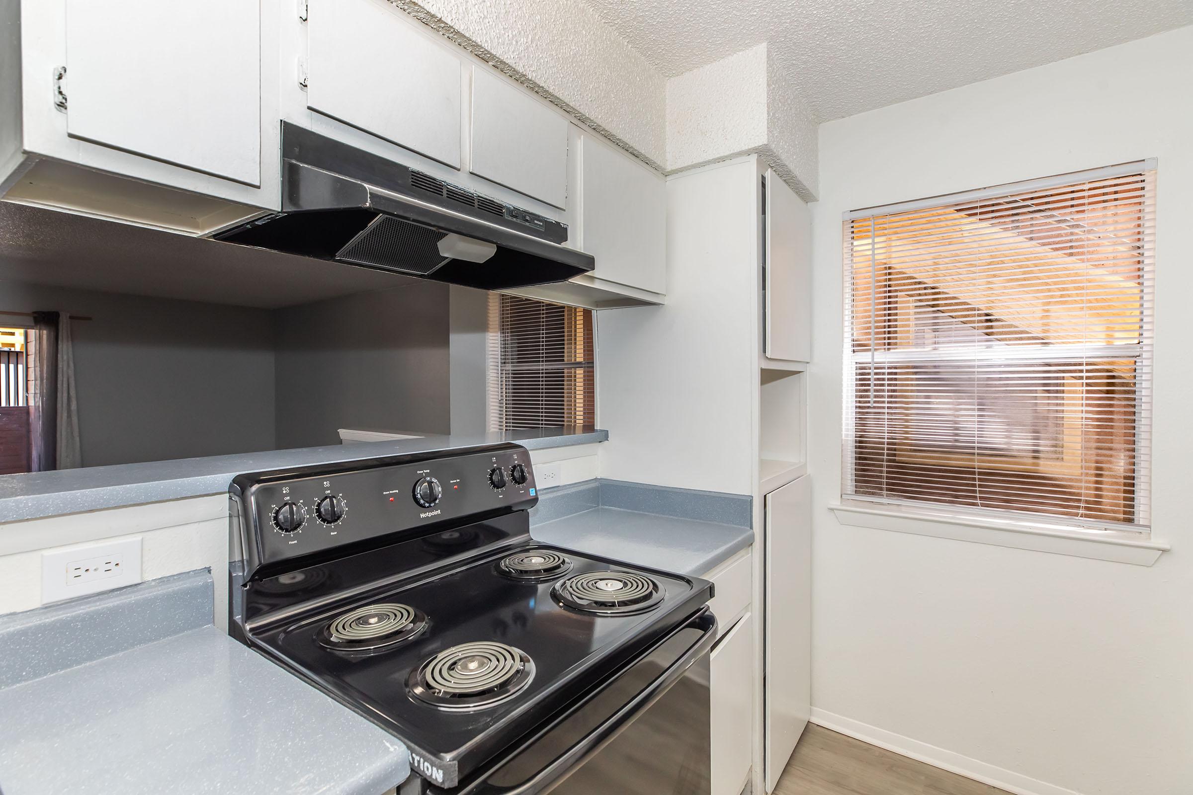 Cocina con estufa nueva y espacio para comedor en Providence at Domain