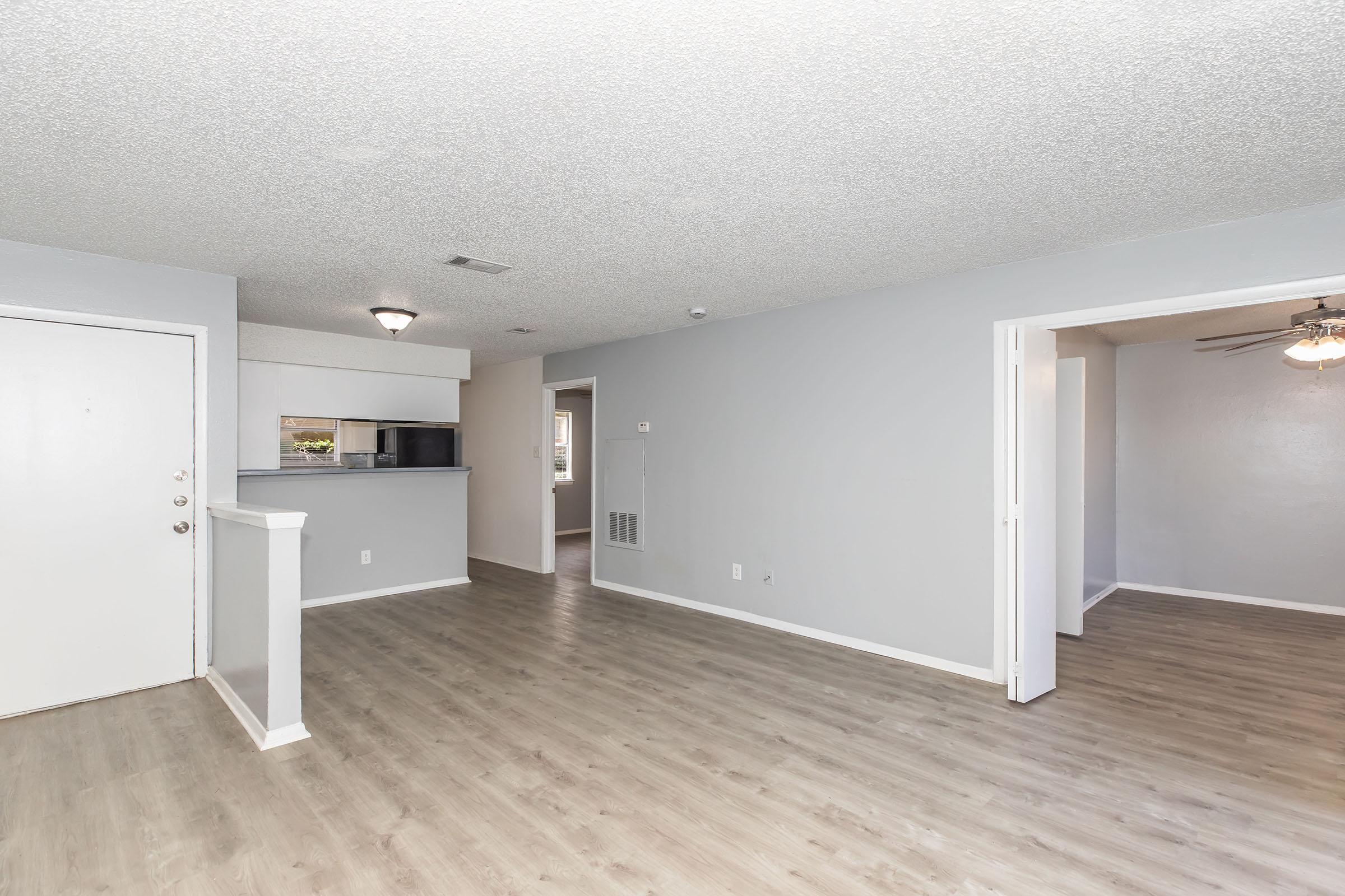 Sala amplia con piso tipo madera en un apartamento de 2 recámaras en Providence at Domain